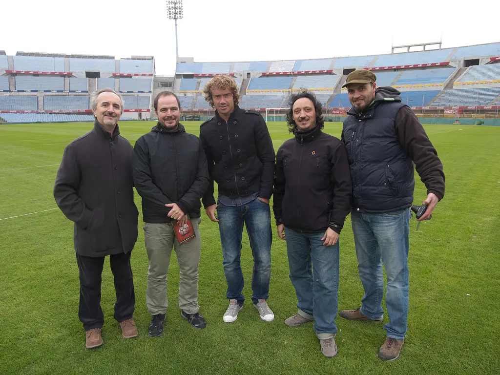 Diego Lugano, al centro, junto a un equipo de filmación durante una entrevista en el campo del Estadio Centenario de Montevideo. Foto: AnselmiJuan / Wikimedia Commons (CC BY-SA 3.0) (archivo)