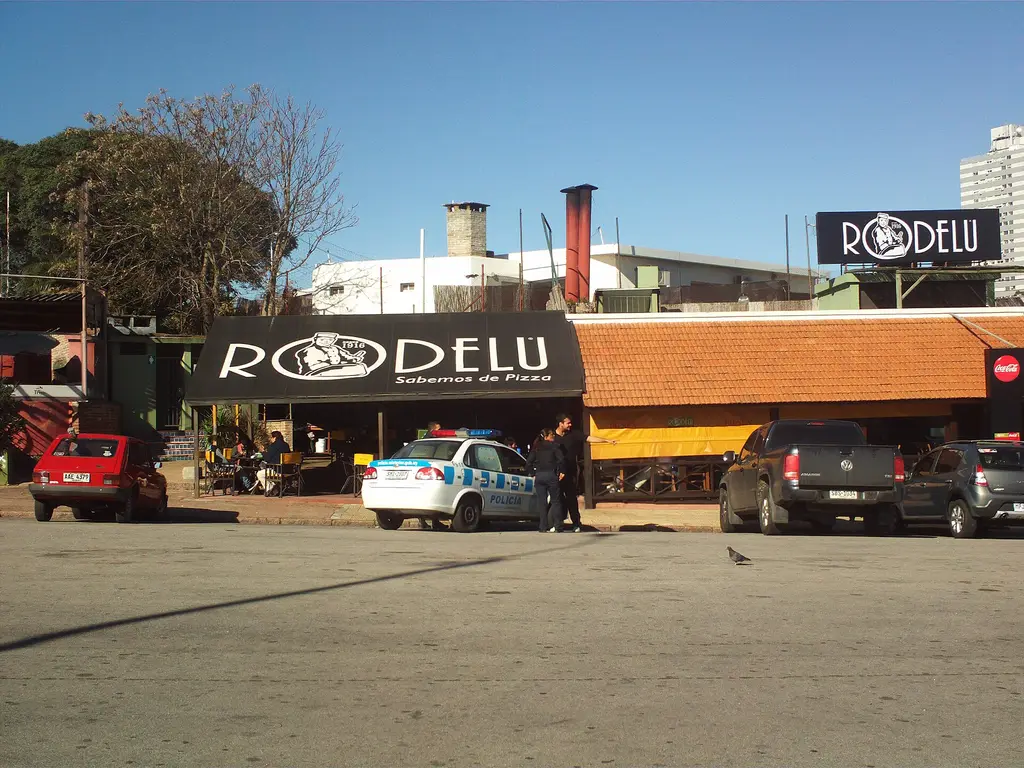 Patrullero de la Policía uruguaya estacionado frente a un comercio en Montevideo, con agentes conversando en la vereda, imagen ilustrativa. Foto: Ypsilon from Finland / Wikimedia Commons (CC0) (archivo)