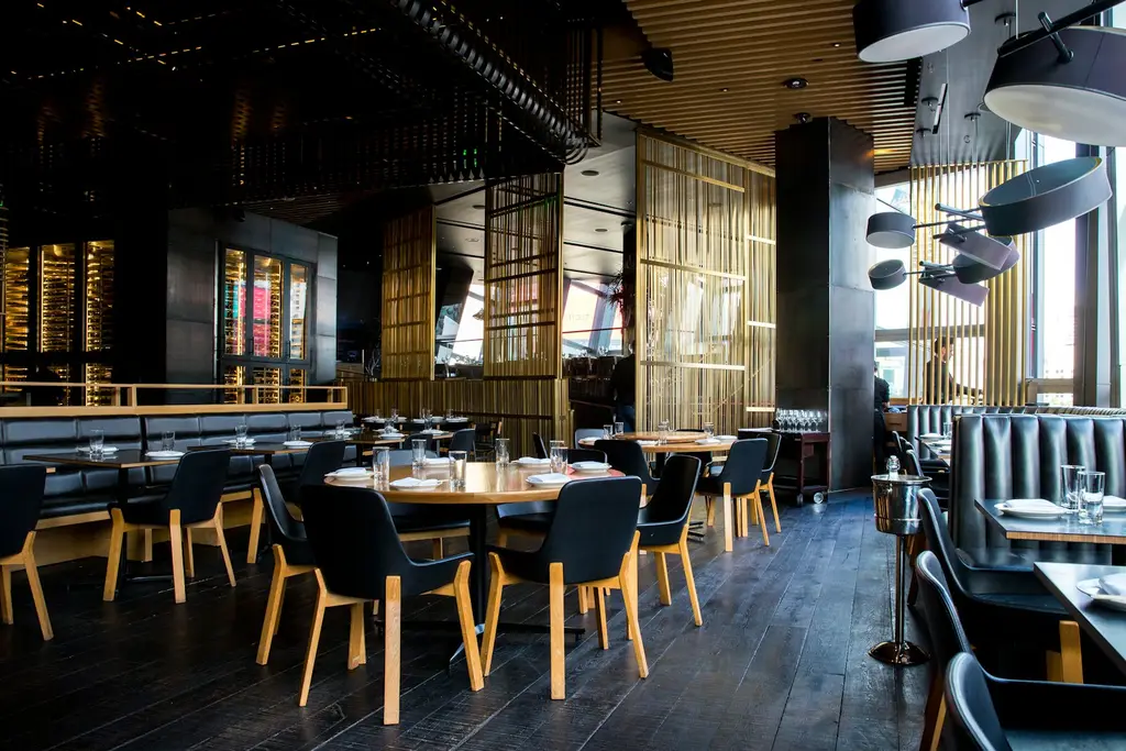 Interior de restaurante con mesas y luces cálidas. Foto: Unsplash
