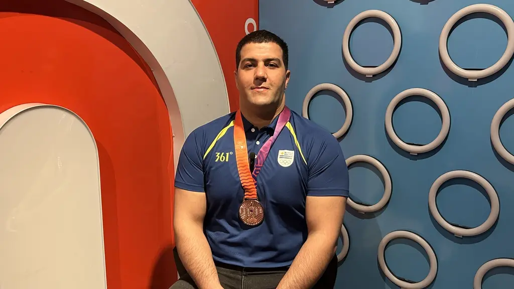 Mohammadreza Beykzadeh, sentado con la medalla de bronce y la camiseta de Uruguay. Foto: Montevideo Portal