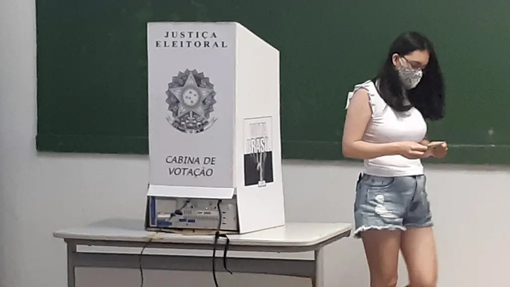 Una votante camina junto a la cabina de votación de la Justicia Electoral con la urna electrónica en una escuela de Brasil. Foto: Senado Federal / Wikimedia Commons (CC BY 2.0) (archivo)