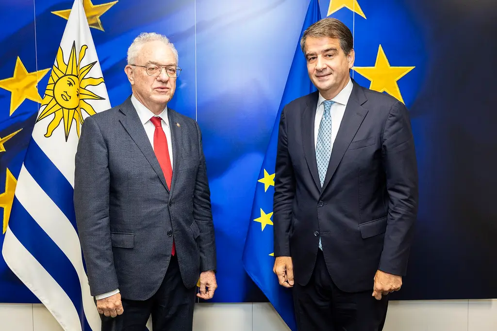 El canciller Mario Lubetkin, a la izquierda, junto a una bandera uruguaya durante una visita a la Comisión Europea. Foto: Lukasz Kobus / Comisión Europea / Wikimedia Commons (CC BY 4.0) (archivo)