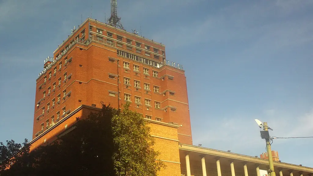 Torre de ladrillo del Palacio Municipal, sede de la Intendencia de Montevideo, con árboles en primer plano. Foto: Ypsilon from Finland / Wikimedia Commons (CC0) (archivo)