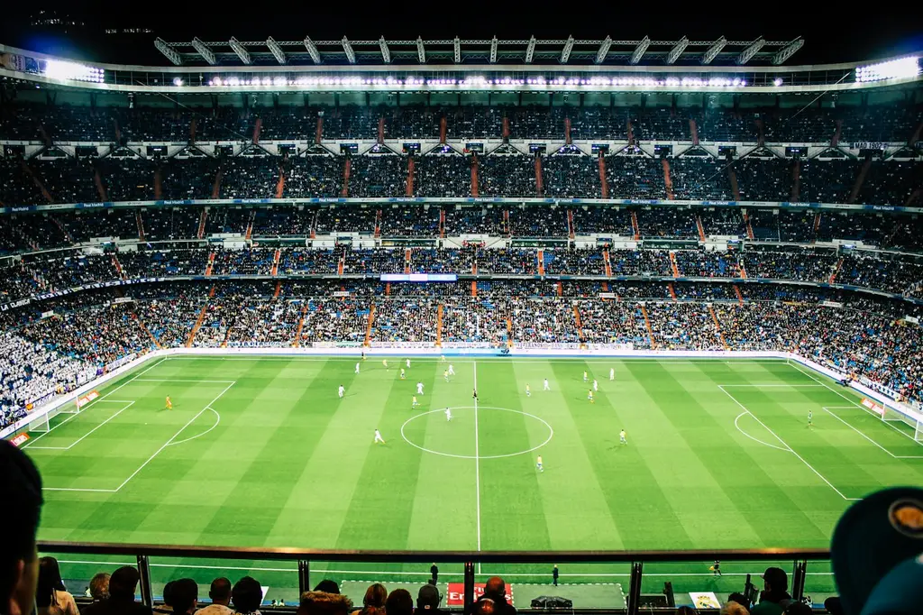 Un partido de fútbol de noche, visto desde la tribuna. Foto: Unsplash