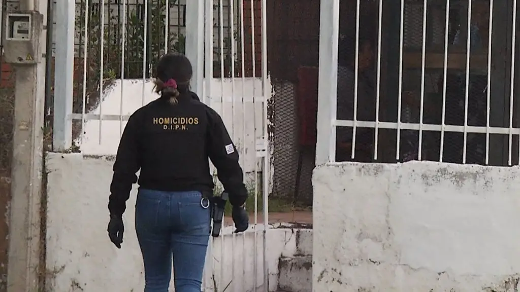 Una agente de Homicidios, de espaldas, en el allanamiento de una casa en Ituzaingó, en una imagen de archivo. Foto: Subrayado