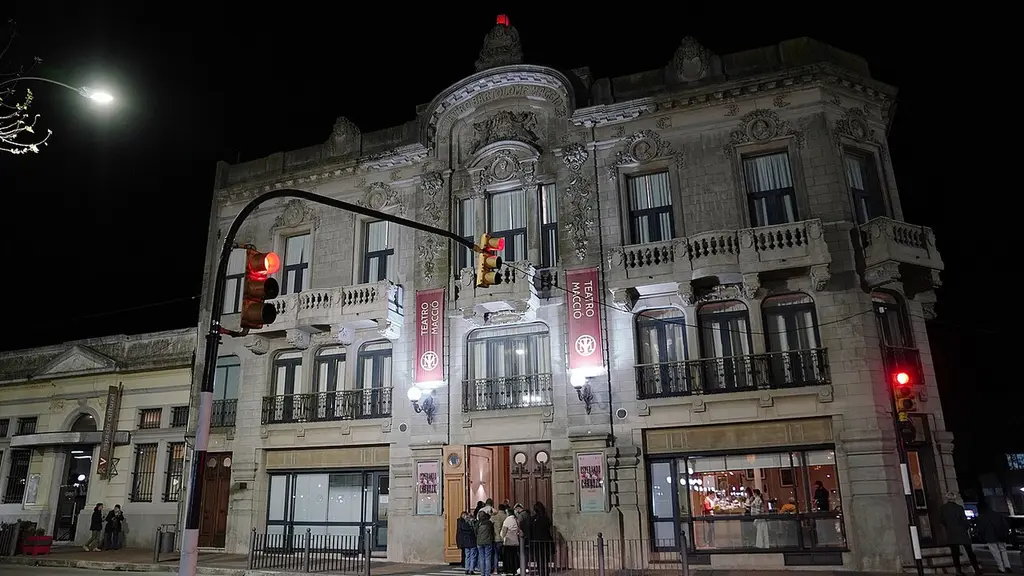 Fachada iluminada del Teatro Macció de San José en una noche de función, con público en la puerta. Foto: Intendencia de Montevideo / Wikimedia Commons (CC BY-SA 4.0) (archivo)