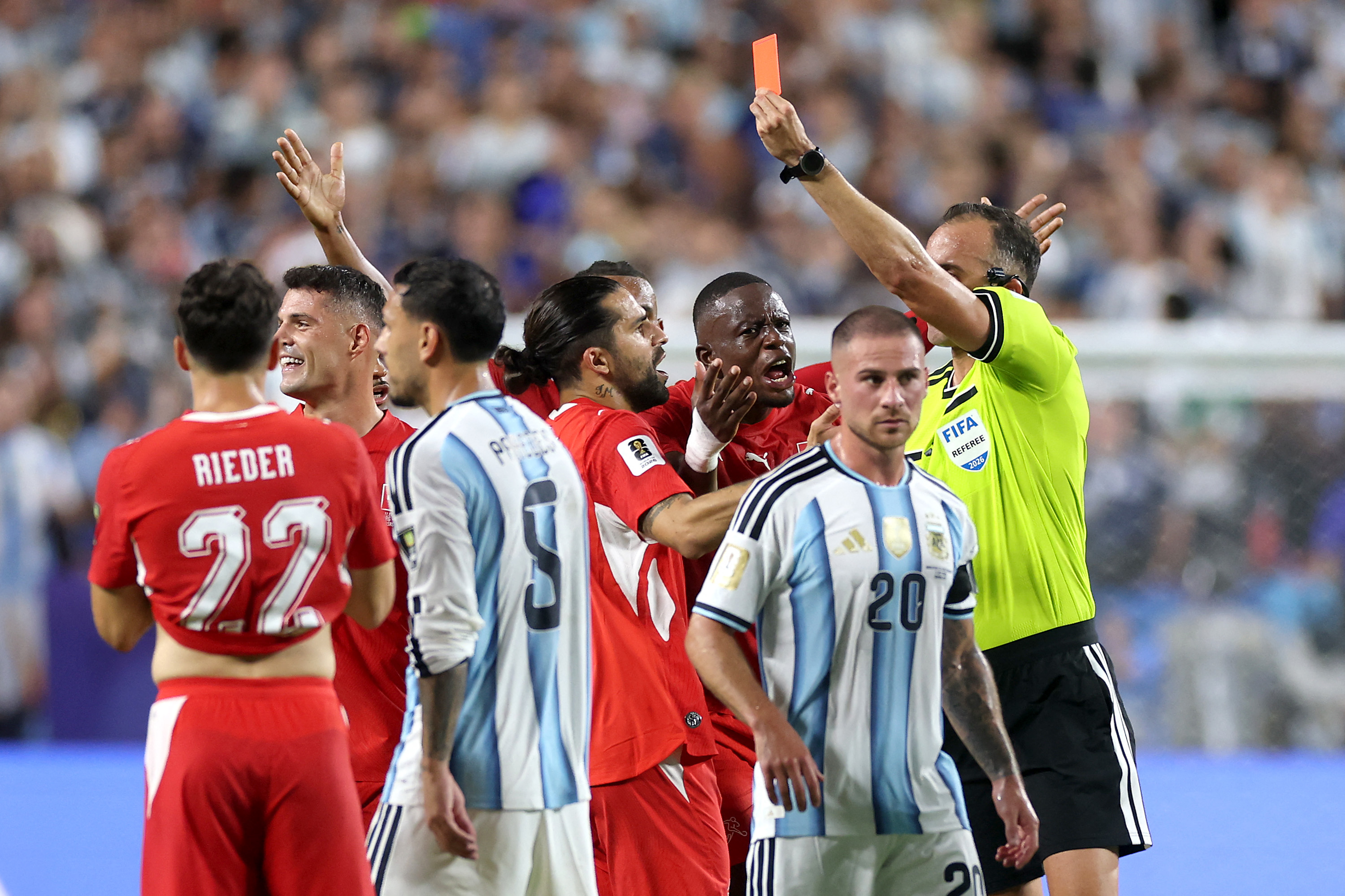 Un árbitro de fútbol mostrando una tarjeta amarilla a un jugador. Foto: Reuters