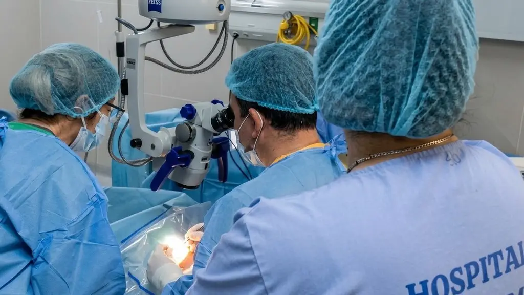 El equipo de oftalmología del Hospital de Tacuarembó durante el trasplante de córnea, con el cirujano trabajando bajo microscopio. Foto: Hospital de Tacuarembó