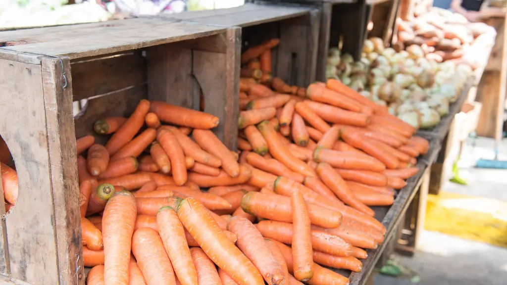 Cajones de madera llenos de zanahorias, con cebollas y papas al fondo, en un puesto de feria vecinal de Montevideo. Foto: Artigas Pessio / Wikimedia Commons (CC BY-SA 4.0) (archivo)