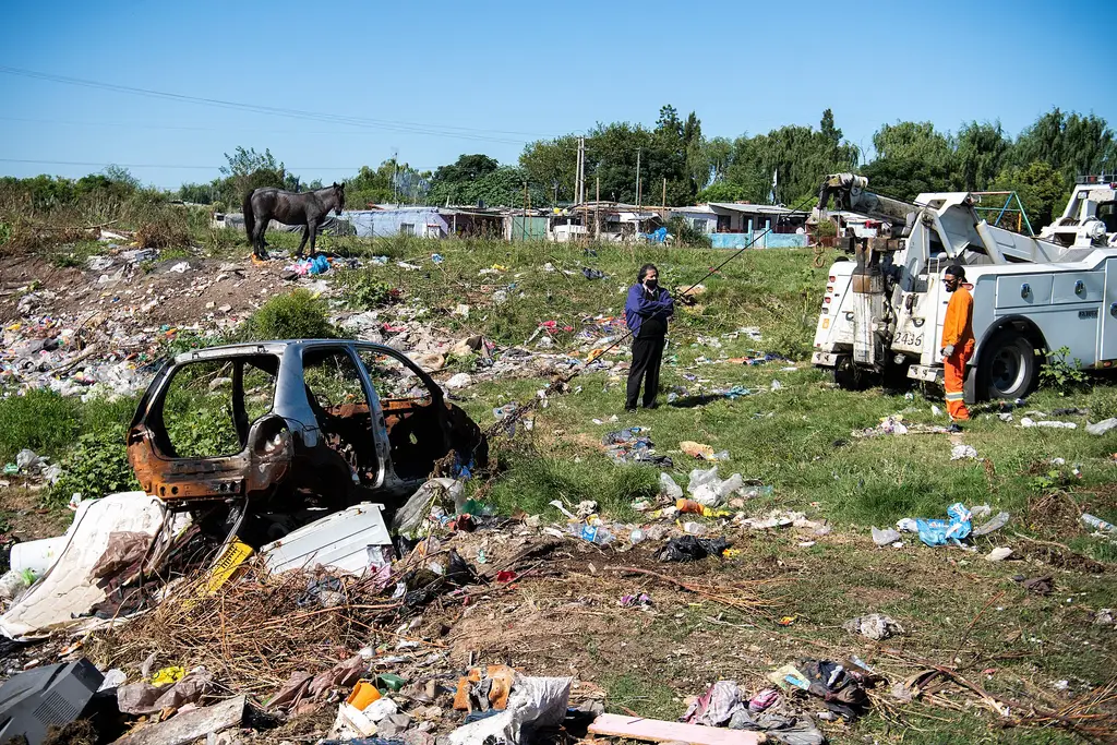 Operarios retiran un auto abandonado de un basural junto a un arroyo durante una limpieza en Montevideo. Foto: Santiago Mazzarovich / Wikimedia Commons (CC BY-SA 4.0) (archivo)