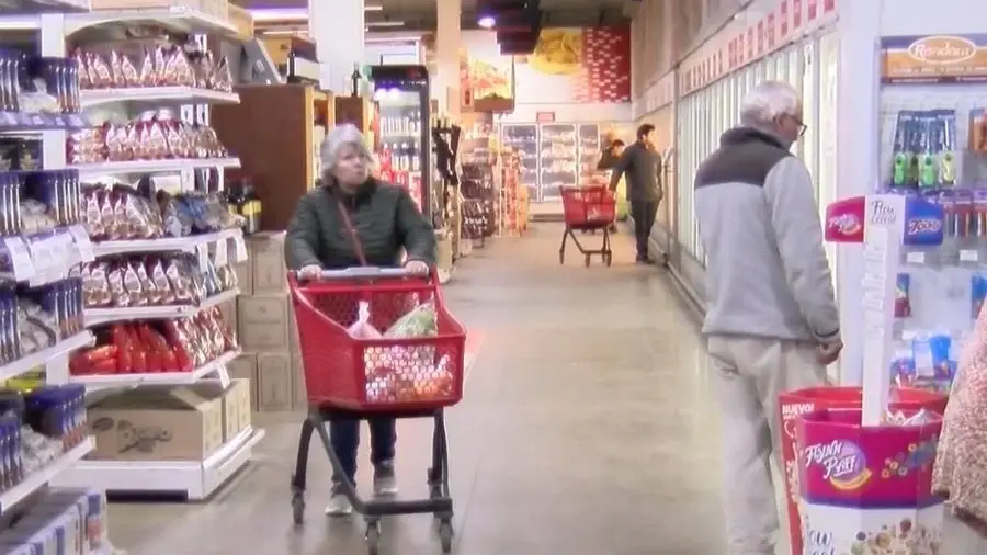 Una mujer empuja un changuito por un pasillo de supermercado. Foto: Subrayado