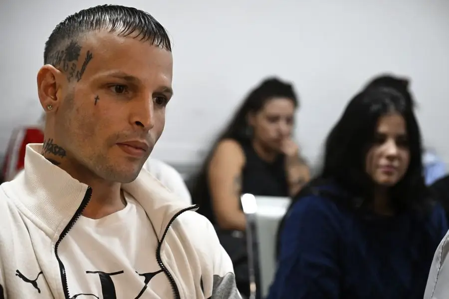 Moisés Martínez, sentado en una audiencia, con dos mujeres detrás. Foto: El País