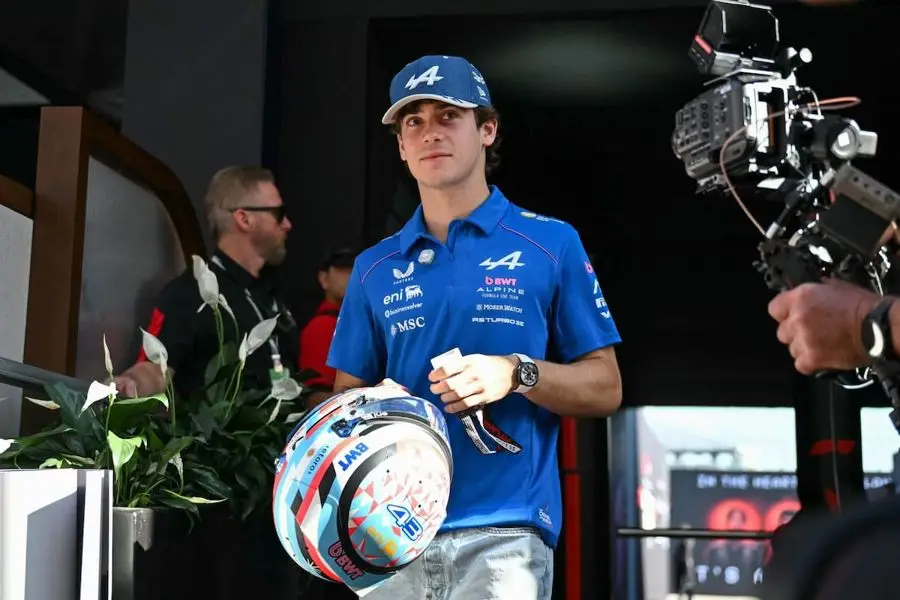 Franco Colapinto, de remera azul de Alpine, camina con el casco en la mano. Foto: Angela Weiss, vía La Nación