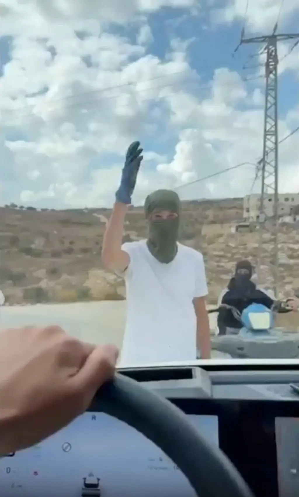 Un hombre encapuchado frena un auto en un camino de Cisjordania. Foto: La Nación