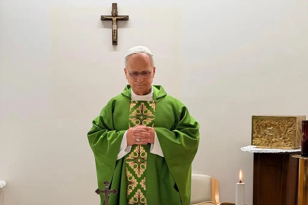 León XIV, con casulla verde, reza con las manos juntas frente a un crucifijo. Foto: La Nación