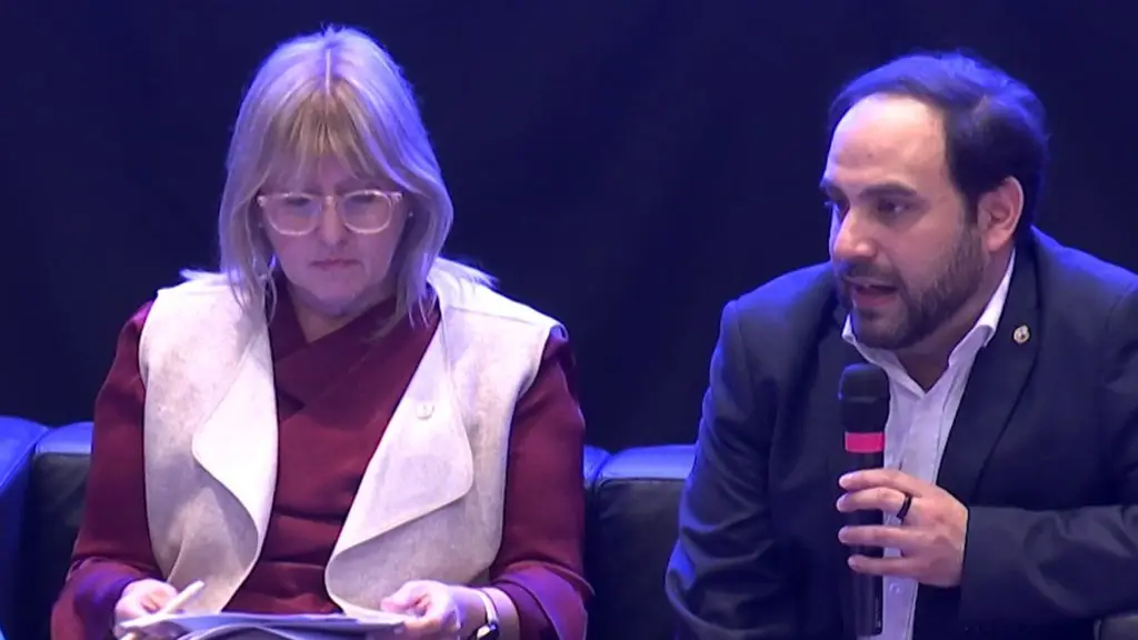 Cristina Lustemberg, con chaleco claro, sentada junto a Gonzalo Civila, que habla por un micrófono. Foto: Subrayado