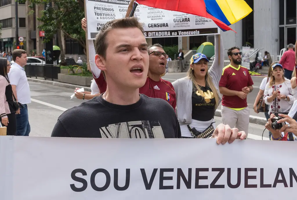 Venezolanos en el exterior marchan con la bandera de su país y una pancarta contra la dictadura, durante una protesta de la diáspora. Foto: Wilfredor / Wikimedia Commons (CC BY-SA 4.0) (archivo)
