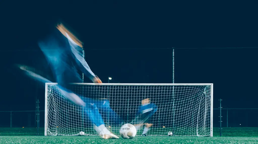 Un futbolista define frente al arco, de noche. Foto: Unsplash