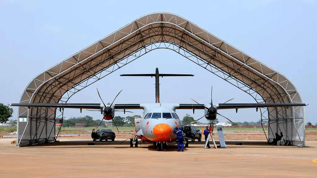 Un avión ATR-42 de la Fuerza Aérea de Nigeria, con la nariz pintada de naranja, estacionado bajo un hangar de lona en una base aérea mientras un técnico trabaja junto a él. Foto: Kenneth Iwelumo / Wikimedia Commons (GFDL 1.2) (archivo, imagen ilustrativa)