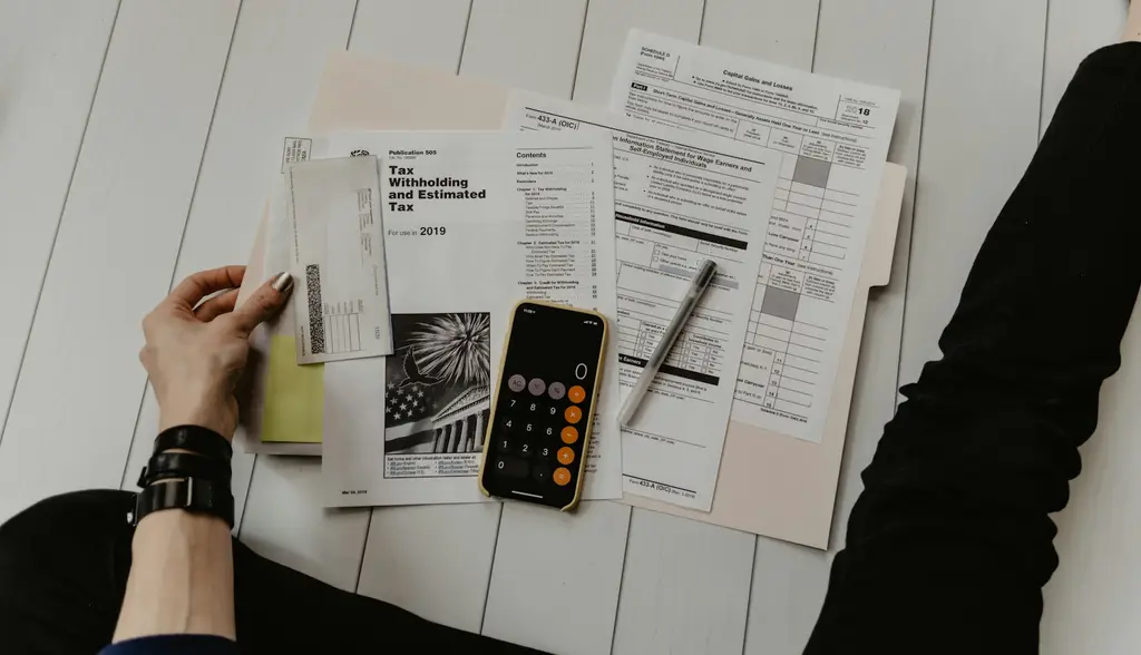 Documentos y calculadora sobre escritorio de finanzas. Foto: Unsplash