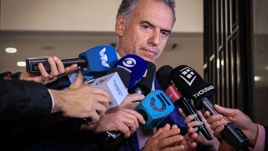 Yamandú Orsi, de saco azul, habla rodeado de micrófonos de la prensa. Foto: El Observador