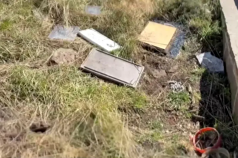 Placas y ofrendas tiradas en el pasto, junto al cementerio de Darwin. Foto: La Nación