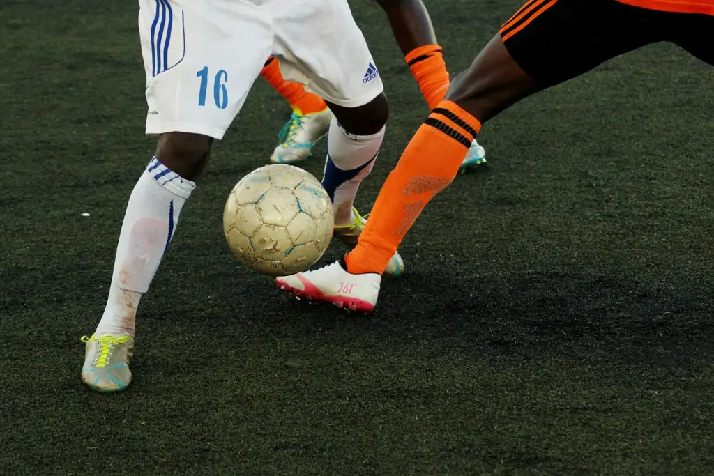 Dos futbolistas disputan la pelota en una cancha. Foto: Unsplash