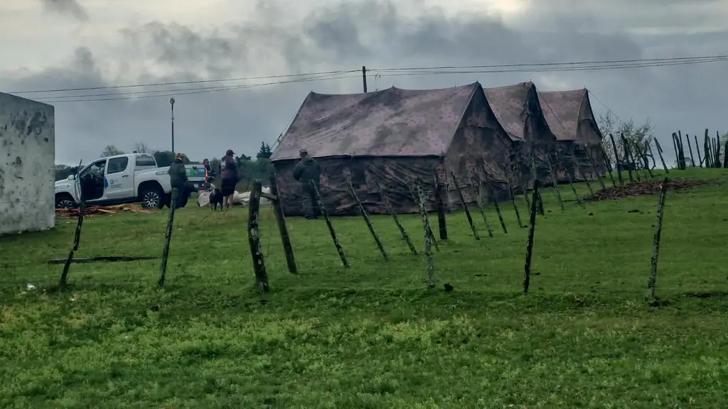 Carpas de campaña armadas en un predio de Paysandú, bajo un cielo gris, durante el temporal. Foto: Marcelo Tortorella