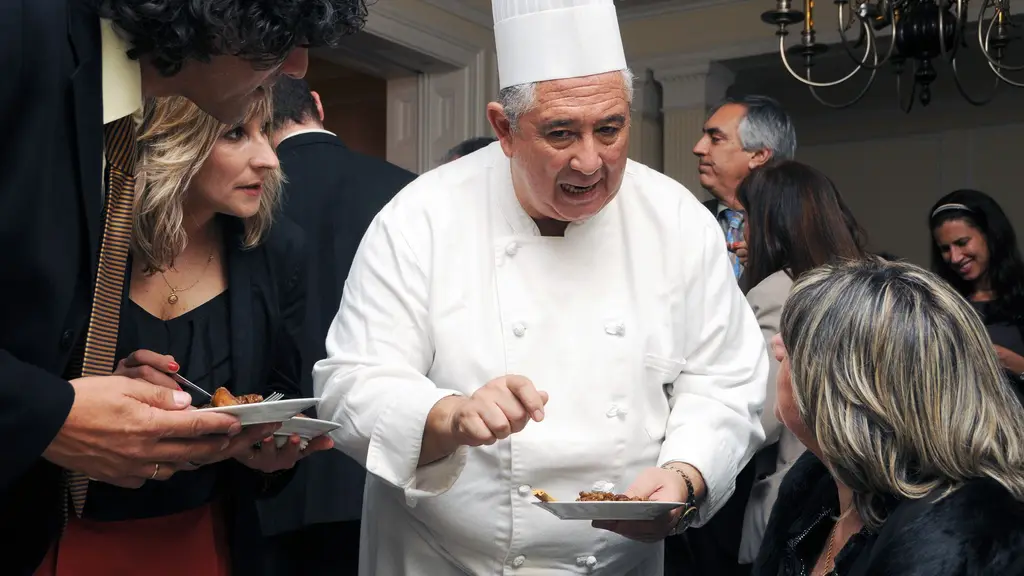 Sergio Puglia, con gorro y chaqueta de chef, sirve platos en una degustación en Montevideo (archivo). Foto: Juan Francisco Casal / Embajada de Estados Unidos en Uruguay / Wikimedia Commons (CC0)