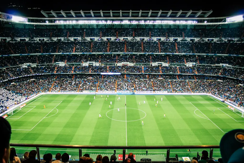 Partido de fútbol en estadio con público. Foto: Unsplash