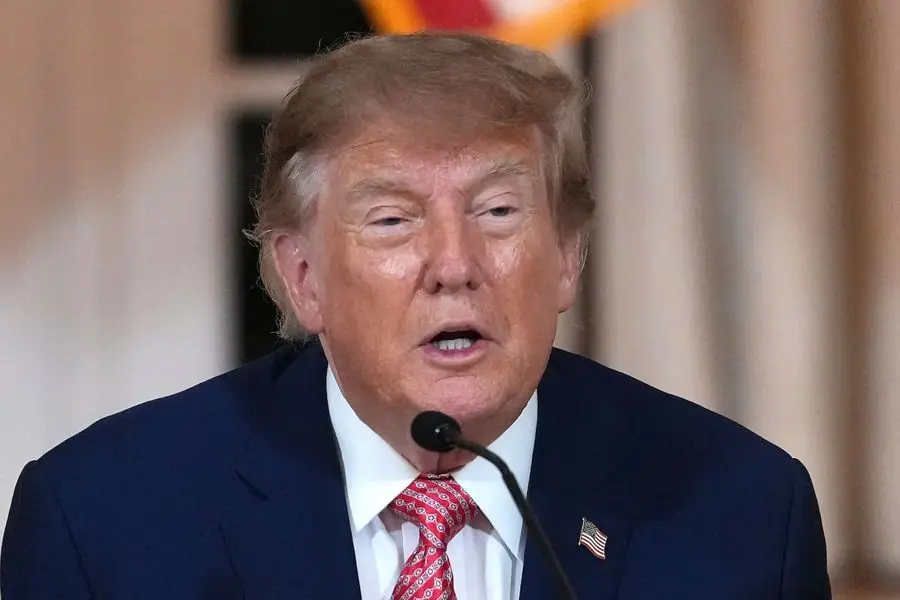 Donald Trump habla ante un micrófono, con traje azul y corbata roja. Foto: La Nación
