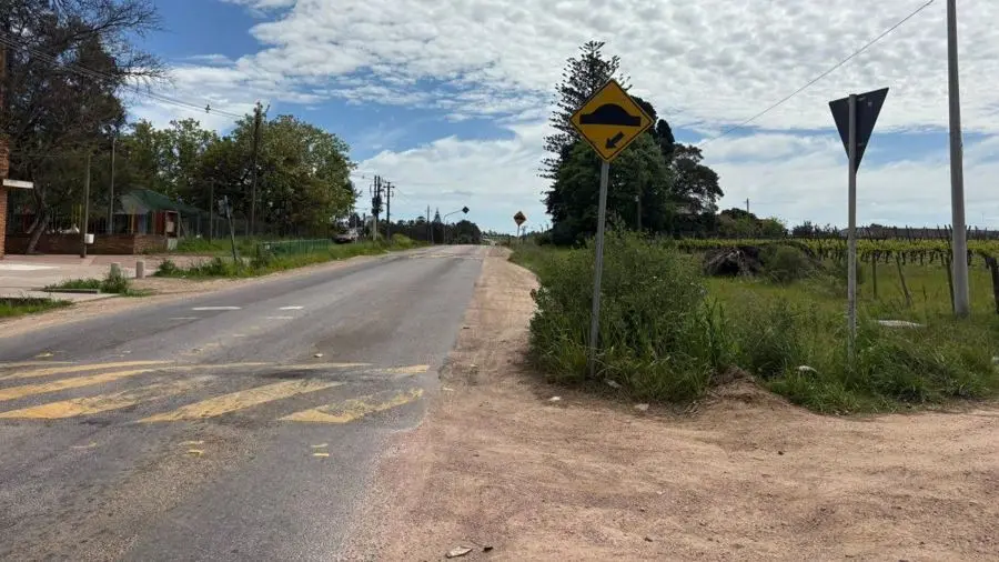 Una calle de asfalto y banquina de tierra en Toledo Chico, con un cartel de lomo de burro. Foto: Subrayado