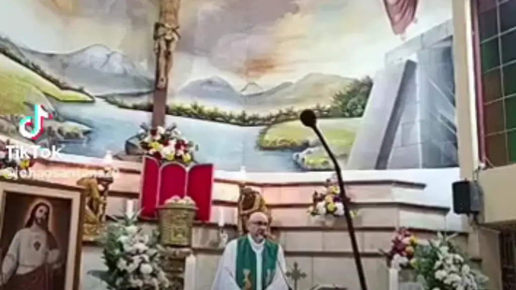 El padre Patricio Sánchez Molinari oficia misa, con una cruz de madera detrás del altar. Foto: Montevideo Portal