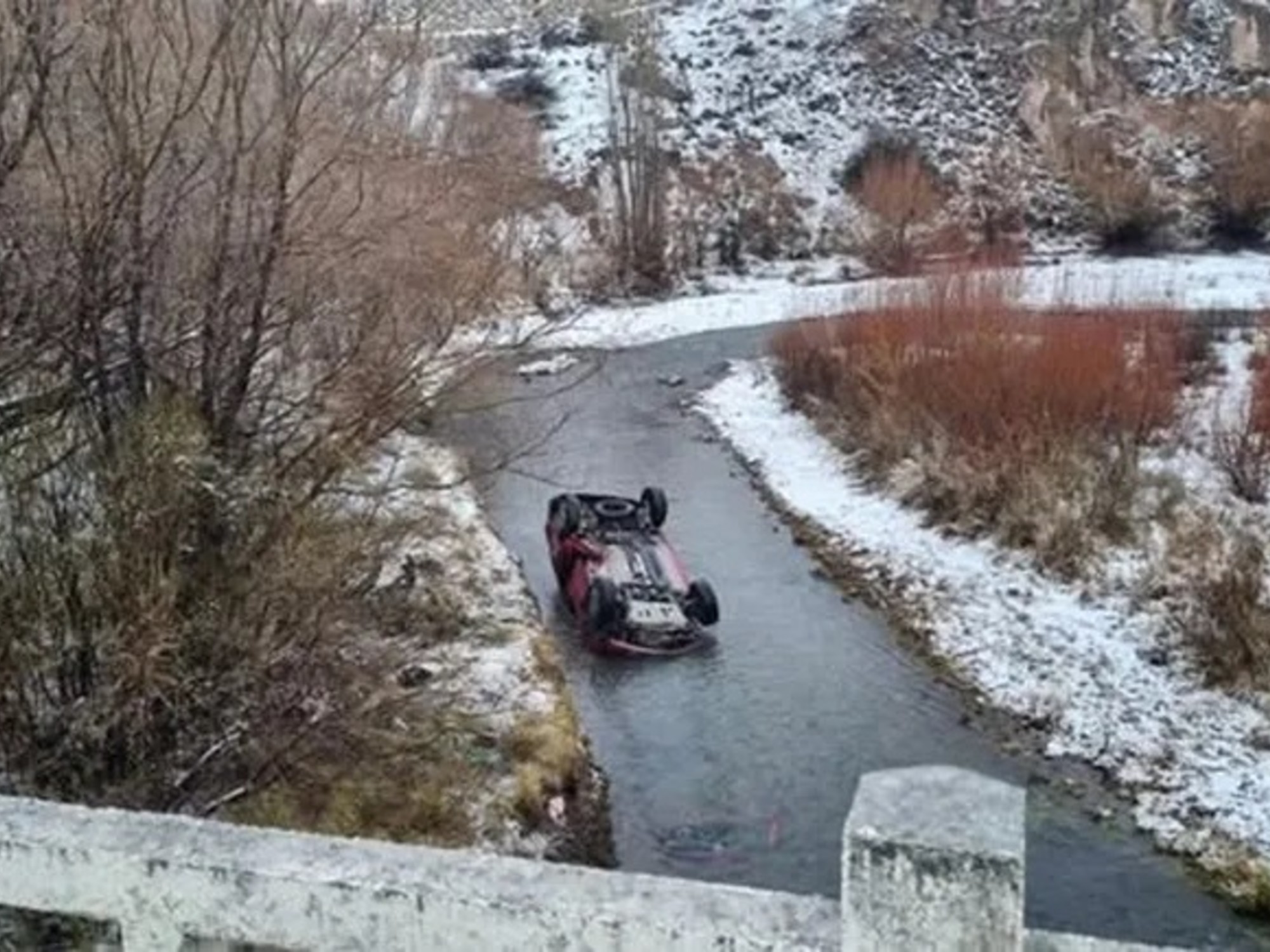 Una camioneta Renault Duster color bordó volcada en un arroyo, con nieve y aguanieve en el fondo. Foto: no disponible