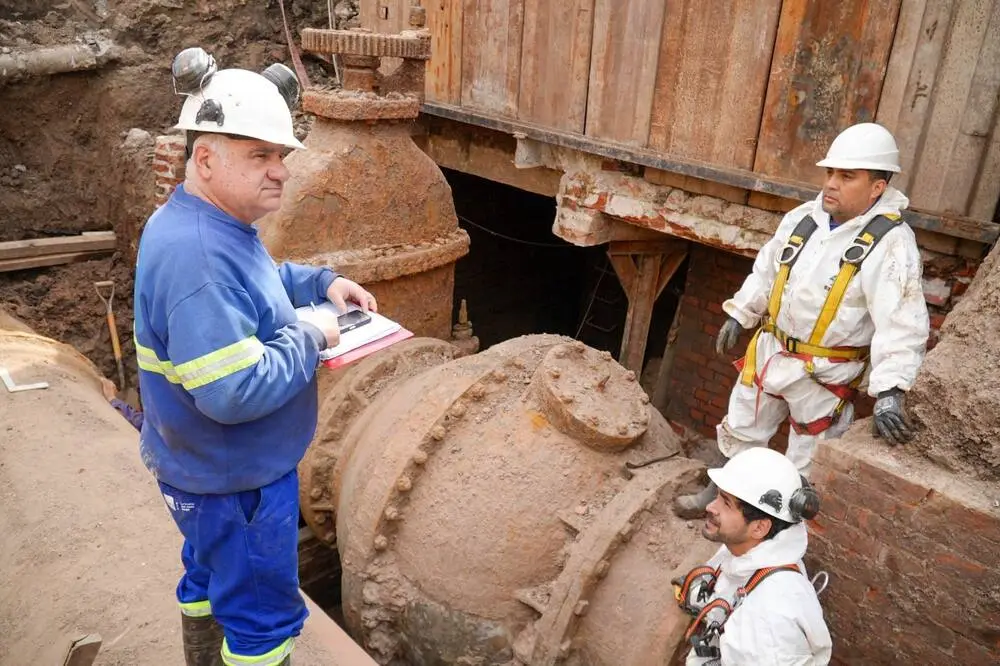 Personal de AySA inspecciona una válvula en una excavación. Foto: La Nación