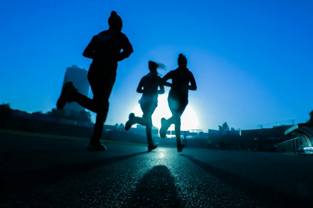 Tres corredoras de espaldas, en silueta, sobre una pista. Foto: Unsplash