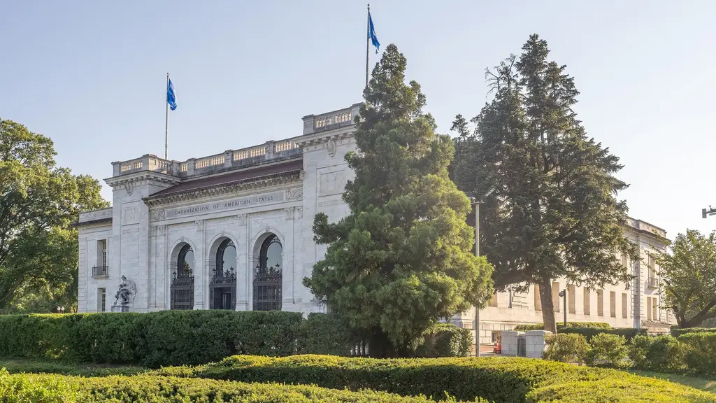 Fachada del edificio de la Organización de los Estados Americanos en Washington, con banderas azules en el techo y árboles en el jardín. Foto: Ajay Suresh / Wikimedia Commons (CC BY 2.0) (archivo)